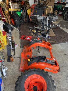 A red tractor sitting in the middle of a garage.