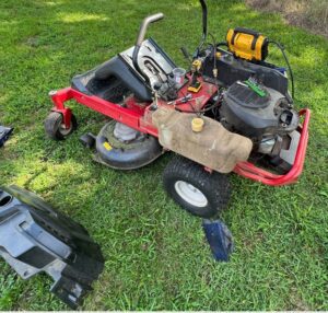 A lawn mower that is sitting in the grass.