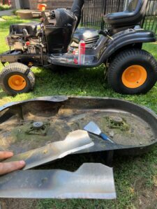 A man is working on an old lawn mower.